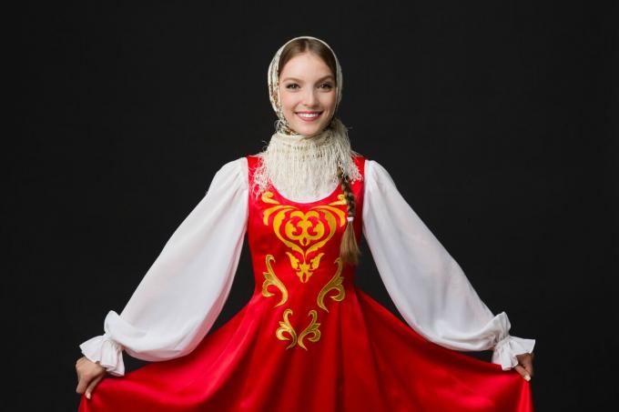 gadis kaukasia tersenyum cantik dengan kostum rakyat rusia