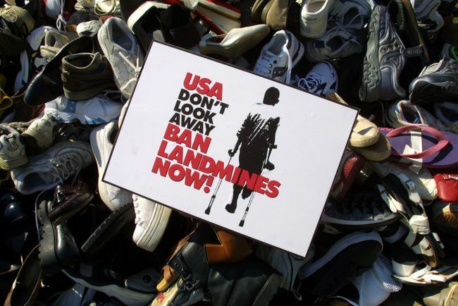 Sebuah tanda larangan ranjau darat ditempatkan di piramida yang ditumpuk oleh sepatu yang dikumpulkan dalam beberapa bulan terakhir oleh Kampanye A.S. untuk Melarang Ranjau Darat.