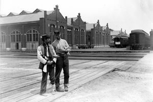 Dua prajurit berdiri di samping Pullman Building dan melatih mobil dengan tangan terkunci dan sebotol minuman keras selama 1894 Chicago Strike Pullman