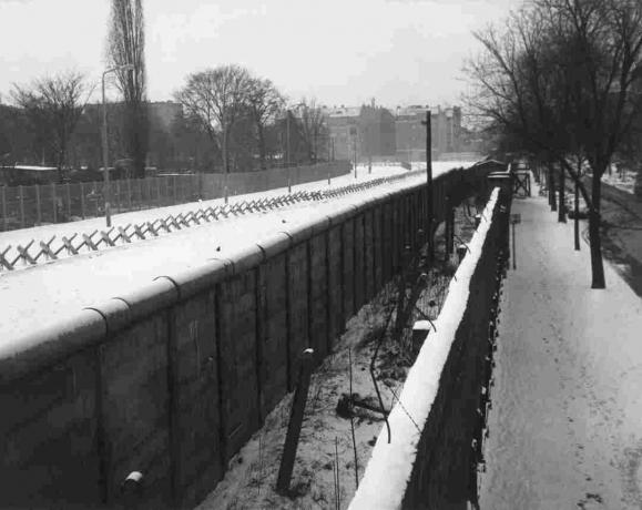 Pemandangan Liebenstrasse Tembok Berlin dengan dinding bagian dalam, parit, dan barikade.