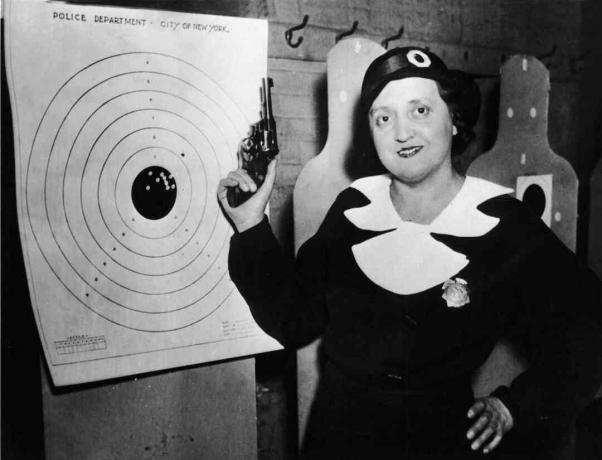 Salah satu dari 105 polisi wanita New York berdiri dengan senjatanya dan sasarannya di lapangan tembak polisi, New York, 12 Desember 1934.