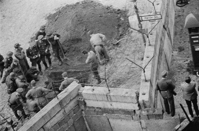 Sekelompok tentara Jerman Timur menyelidiki terowongan yang digali di bawah tembok Berlin.