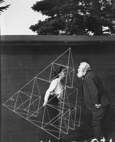 Alexander Graham Bell menghadap istrinya, Mabel Hubbard Gardiner Bell, yang berdiri di layang-layang tetrahedral.