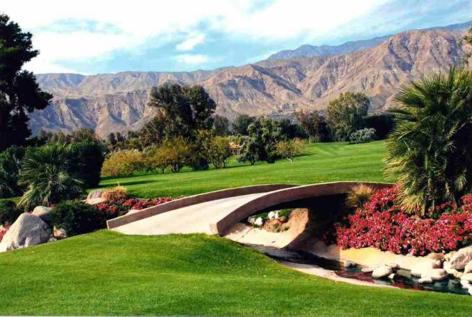 Sebuah jembatan melintasi sungai di lapangan golf yang menghadap ke pegunungan California selatan.