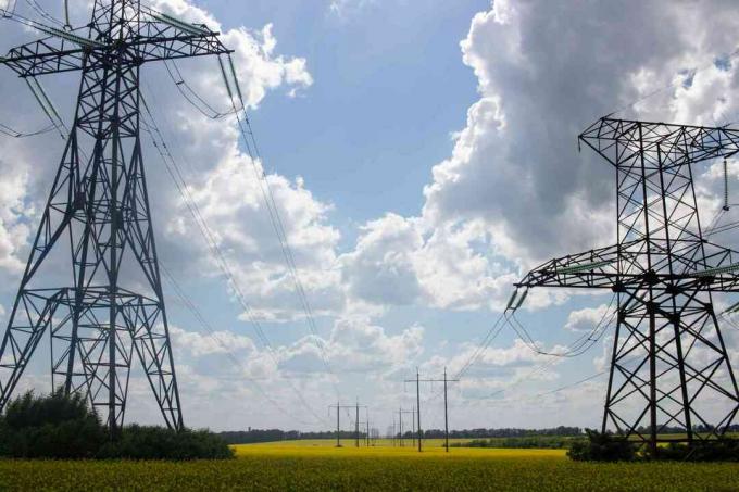 Kabel listrik melewati ladang untuk melayani kebaikan bersama.