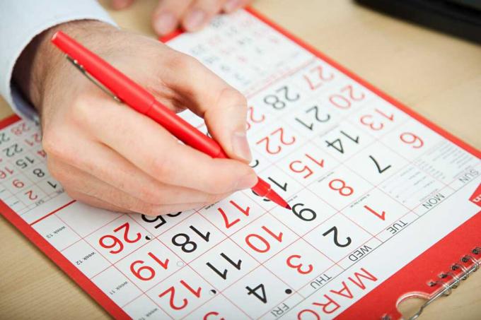 Mano eligiendo fecha sobre calendario.