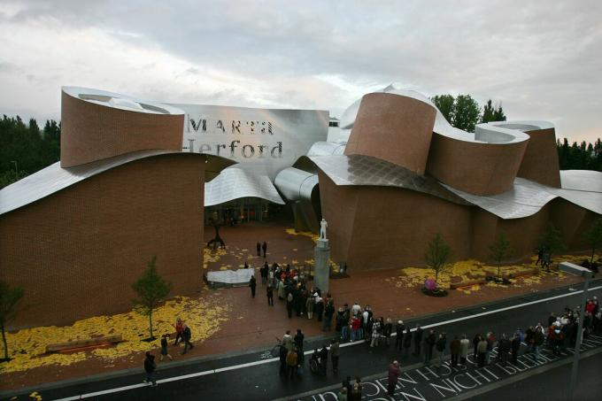 pemandangan panjang atap logam bergelombang di bangunan bata merah bernama MARTa Herford - Orang-orang berbaris untuk memasuki museum 'MARTa' pada 7 Mei 2005 di Herford, Jerman. Museum seni dan desain kontemporer, yang dirancang oleh arsitek bintang AS Frank Gehry, menawarkan ruang pameran seluas 2.500 meter persegi dan selesai setelah waktu konstruksi empat tahun.