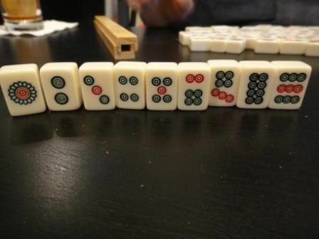 Setelan batu dari satu set ubin Mahjong standar berdiri di atas meja.