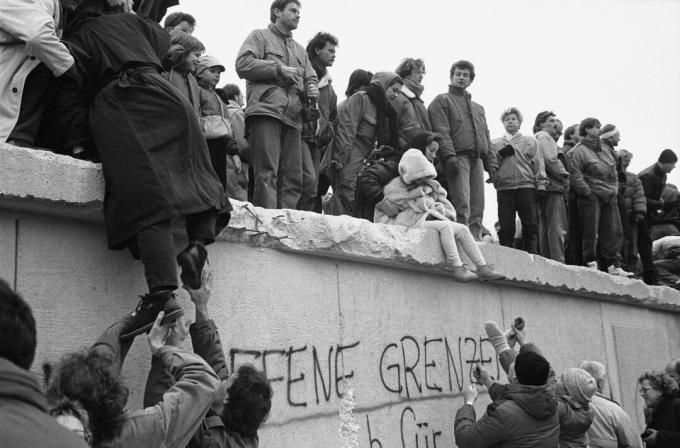 Warga Berlin Timur di atas Tembok Berlin, 1989