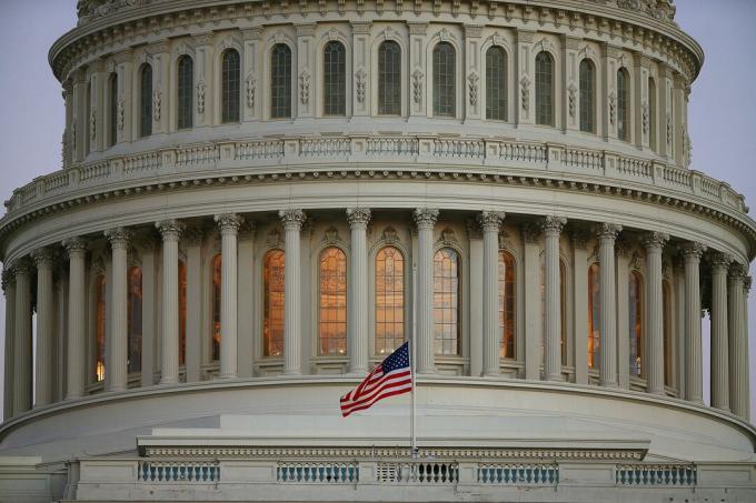 Tampilan dekat kubah US Capitol dengan bendera setengah staf