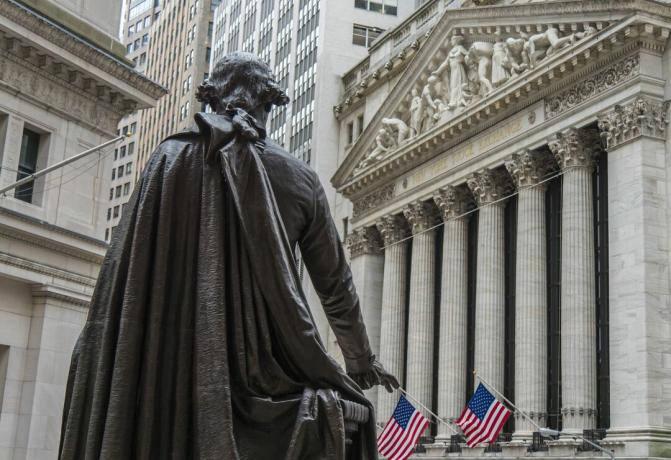 Patung George Washington memandang ke arah gedung Bursa Efek New York di Broad Street dari Federal Hall National Memorial di Wall Street di New York City.