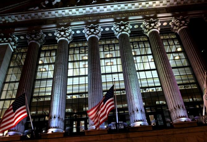 Pemandangan malam melalui fasad dinding tirai kaca New York Stock Exchange (NYSE), dirancang oleh George B. Pos