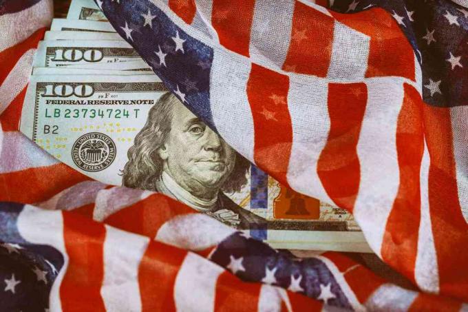 Bendera AS melilit uang seratus dolar.
