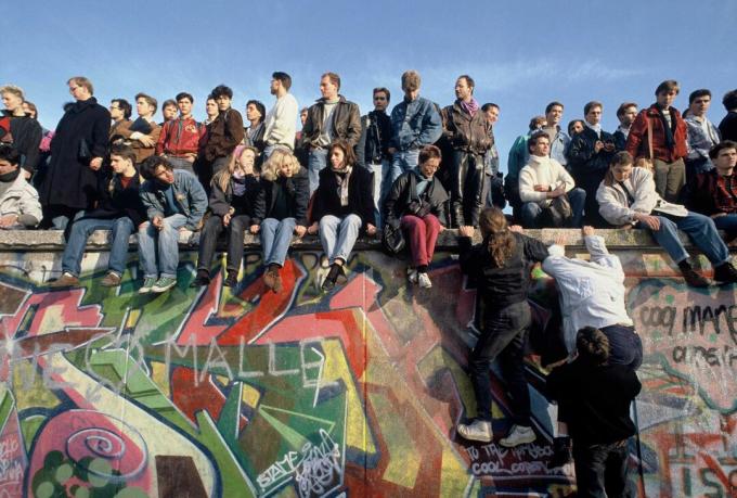 Orang-orang memanjat Tembok Berlin pada 10 November 1989 dalam perayaan.