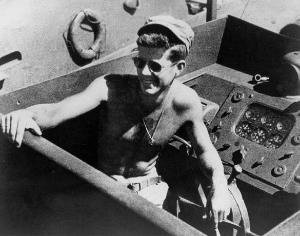 John F. Kennedy, bertelanjang dada dan mengenakan kacamata hitam saat memimpin PT-109.