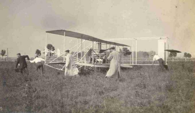 Siswa memindahkan selebaran Wright B di Huffman Prairie Flying Field