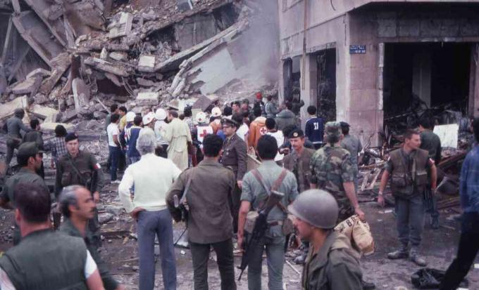 Kerumunan tentara dan pemberi bantuan berdiri di tengah kehancuran dan kerusakan di lokasi pemboman bunuh diri Kedutaan Besar Amerika, Beirut, Lebanon, 18 April 1983.