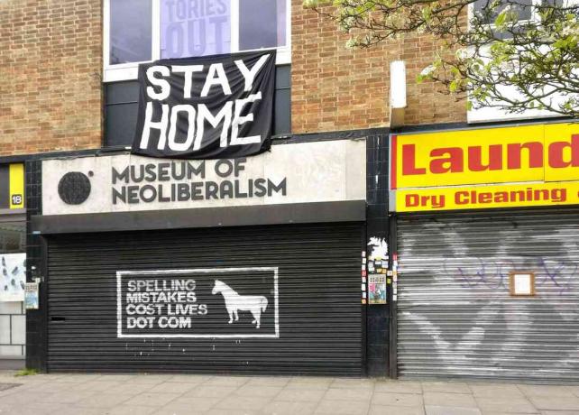 Tanda TINGGAL RUMAH yang besar di atas tutup Museum Neoliberalisme di Lewsiham, London, Inggris.