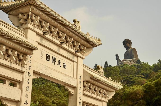 Pintu masuk Cina di latar depan dan patung besar di latar belakang